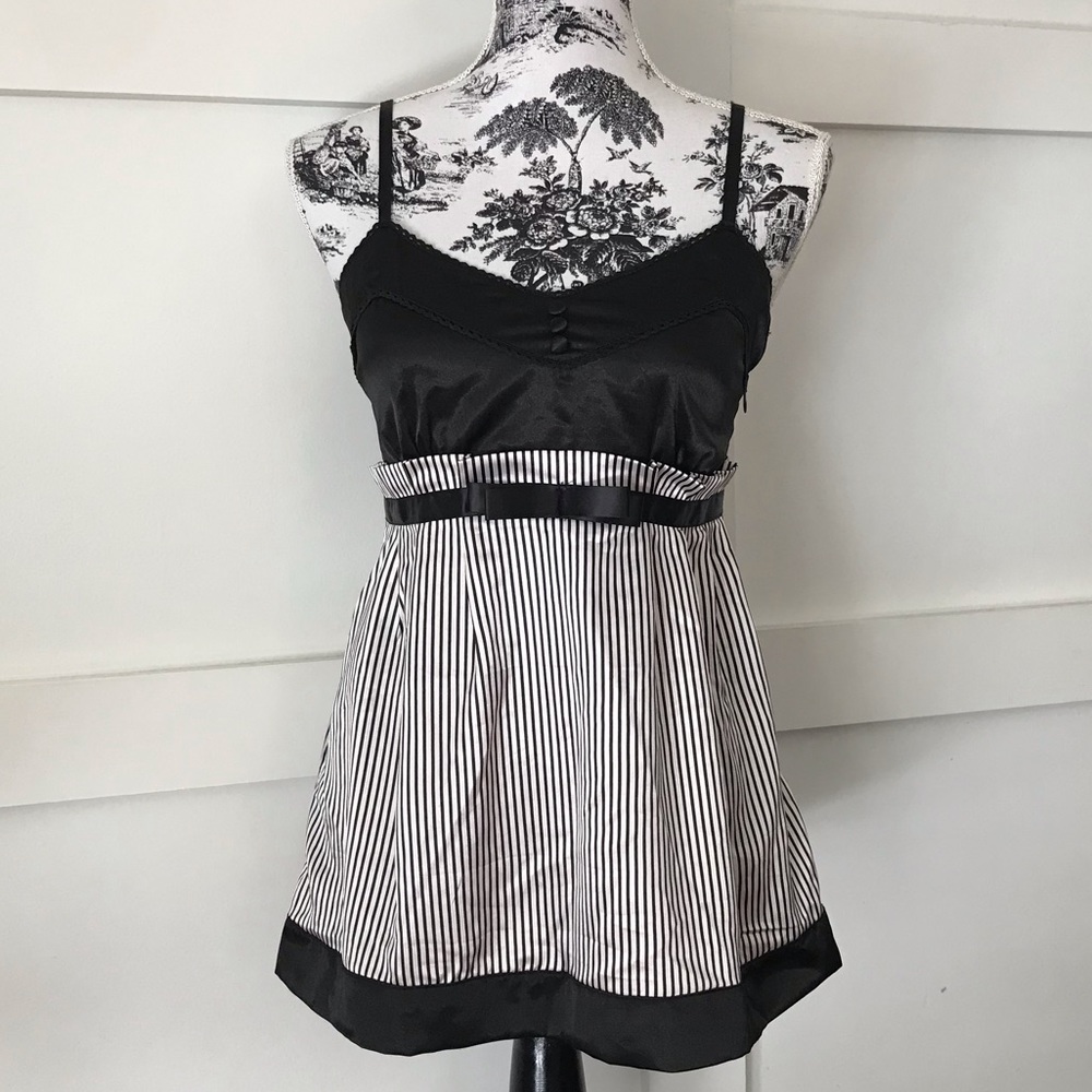 Tank top with buttons and peplum style and bow.